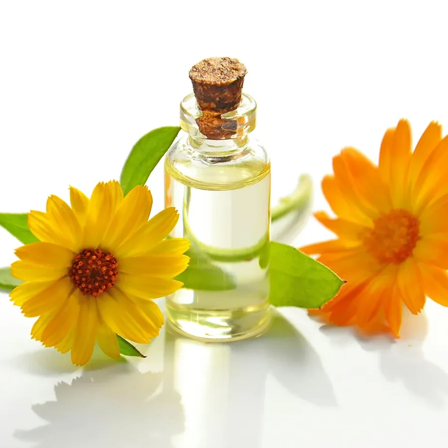 Ram de flors taronges amb pot de vidre de perfum natural, ideal per ambientar la llar a l’estiu.